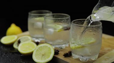 Buz ve limon dilimleri ile cam içine limon suyu dökün. Limonalkollü kokteyl