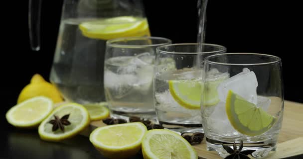 Pour lemon juice into glass with ice and lemon slices. Lemon alcoholic cocktail — Stock Video