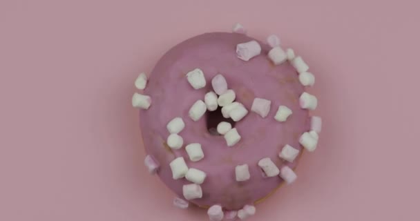 Sweet donut rotating on pink background. Top view. Tasty, fresh donut — Stock Video