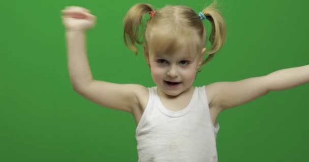 Gelukkig klein meisje in wit t-shirt. Schattige blonde kind. Dansen en gezichten maken — Stockvideo