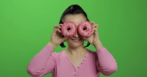 Feliz joven hermosa posando y divirtiéndose con donuts. Clave de croma — Vídeos de Stock