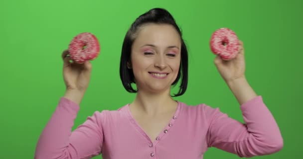 Feliz joven hermosa posando y divirtiéndose con donuts. Clave de croma — Vídeo de stock