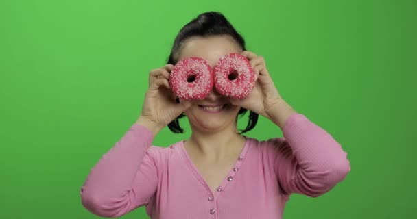 Feliz joven hermosa posando y divirtiéndose con donuts. Clave de croma — Vídeos de Stock