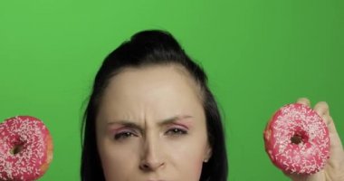 Mutlu güzel genç kız poz ve çörekler ile eğleniyor. Renk anahtarı