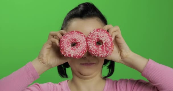 Feliz joven hermosa posando y divirtiéndose con donuts. Clave de croma — Vídeos de Stock