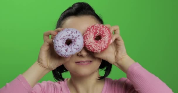 Glücklich schönes junges Mädchen posiert und Spaß mit Donuts hat. Chroma-Schlüssel — Stockvideo