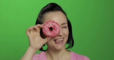 Mutlu güzel genç kız poz ve donut ile eğleniyor. Renk anahtarı