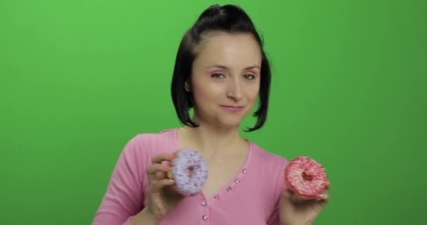 Glücklich schönes junges Mädchen posiert und Spaß mit Donuts hat. Chroma-Schlüssel — Stockvideo