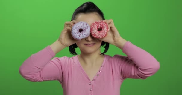 Feliz joven hermosa posando y divirtiéndose con donuts. Clave de croma — Vídeos de Stock