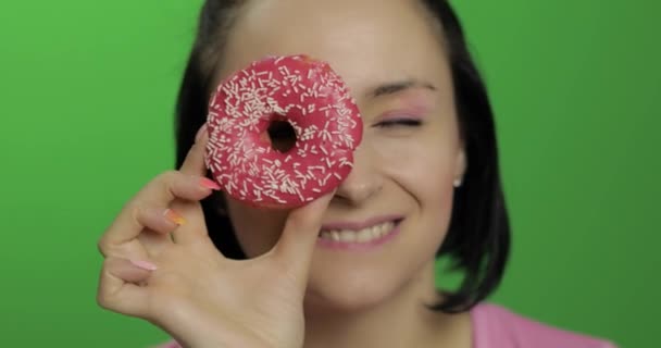 Šťastná mladá dívka pózná a baví se s koblihy. Klíč Chroma — Stock video