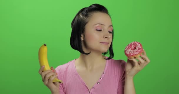 Gezond eten beginnen. Zeg nee tegen junk food. Keuze donut of banaan om te eten — Stockvideo