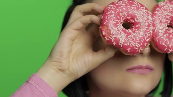 Feliz joven hermosa posando y divirtiéndose con donuts. Clave de croma — Vídeos de Stock