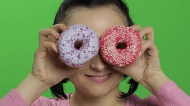 Gelukkig mooi jong meisje poseren en plezier met donuts. Chroma Key — Stockvideo