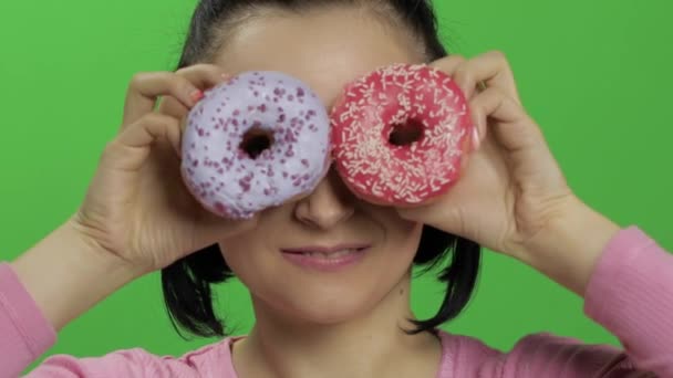 Gelukkig mooi jong meisje poseren en plezier met donuts. Chroma Key — Stockvideo