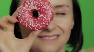 Mutlu güzel genç kız poz ve donut ile eğleniyor. Renk anahtarı