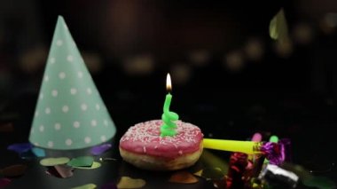 Parti. Pembe donut ve üzerinde kırmızı bir şenlikli mum. Altın konfeti sonbahar
