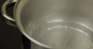 Su gümüş tencerede, çikolata veya yemek yapmak için hazır kavram kaynatıyor