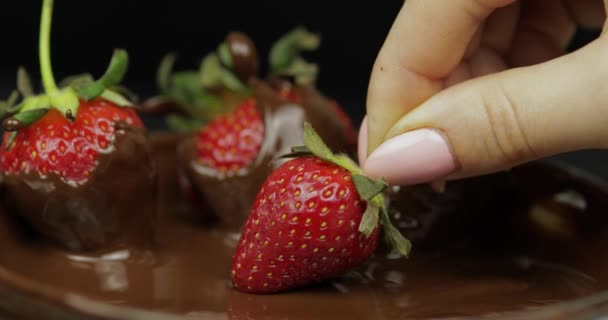 Hand dippen aardbei in gesmolten chocolade. Verse bessen zoete dessert eten — Stockvideo