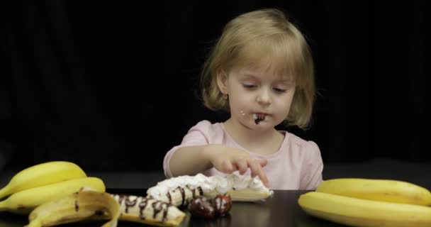 Criança come banana, morango com chocolate derretido e chantilly — Vídeo de Stock