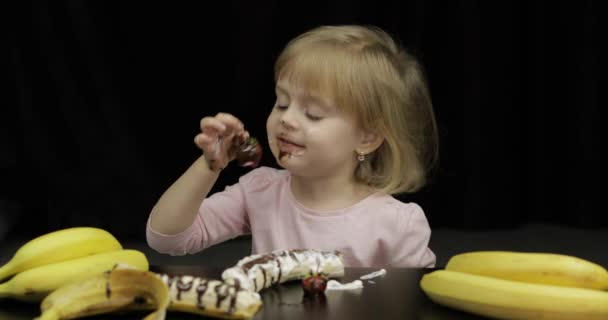 Kind isst Banane, Erdbeere mit geschmolzener Schokolade und Schlagsahne — Stockvideo