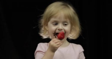 Erimiş çikolata ve krem şanti kirli yüzü ile Çocuk çilek yiyor