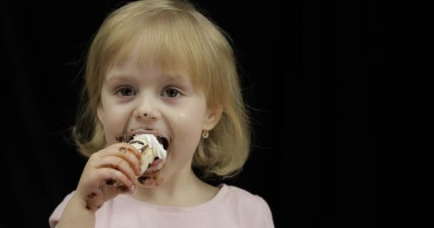 더러운 얼굴을 가진 아이는 녹은 초콜릿과 휘핑 크림바나나를 먹는다. — 비디오