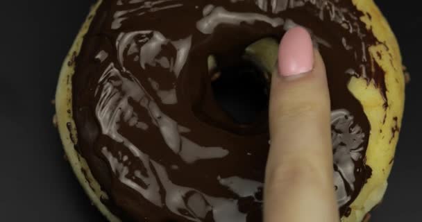 Doigt des femmes touche le chocolat fondu noir sur un délicieux beignet — Video