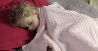 Sevimli bebek evde yatakta uyuyor. Küçük kız sabah ışığında uyku