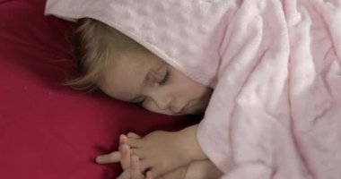 Sevimli bebek evde yatakta uyuyor. Küçük kız sabah ışığında uyku