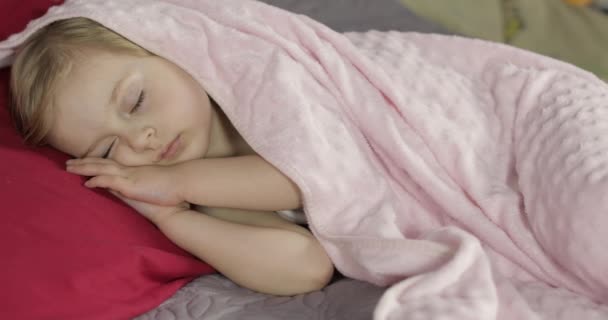Söt bebis sova på sängen hemma. Liten flicka sover i morgonljus — Stockvideo