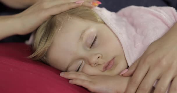Młoda matka opiekuje się swoją córeczką podczas snu. Dziewczyna w łóżku — Wideo stockowe