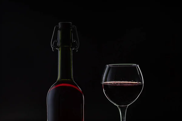 Rosenwein. Rotwein in Flasche mit Weinglas vor dunklem Hintergrund. Silhouette — Stockfoto