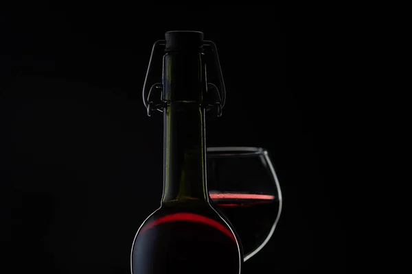 Vino rosa. Vino tinto en botella con copa de vino sobre fondo oscuro. Silueta — Foto de Stock