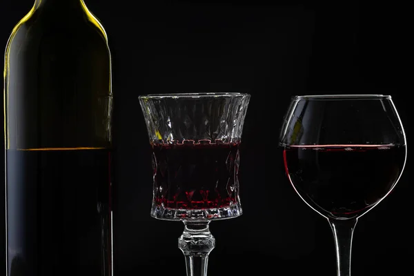 Rosenwein. Rotwein in Flasche mit zwei Weingläsern vor dunklem Hintergrund — Stockfoto