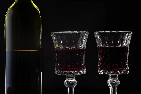 Vino rosato. Vino rosso in bottiglia con due bicchieri di vino su sfondo scuro — Foto Stock