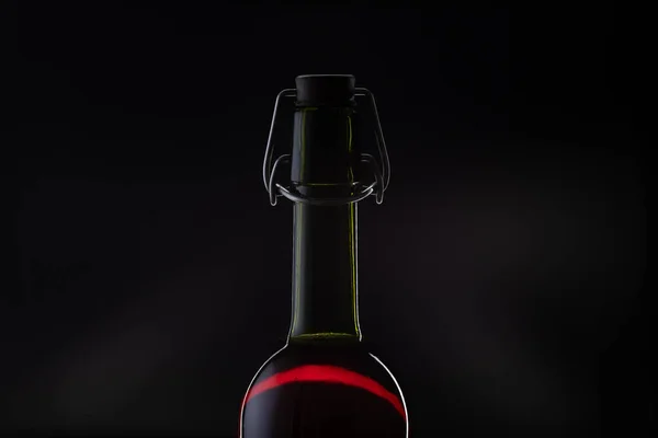 Ροζέ κρασί. Κόκκινο κρασί σε μπουκάλι και μεταλλικό ανοιχτήρι στο φελλό. Σκούρο φόντο — Φωτογραφία Αρχείου