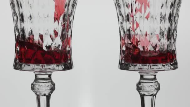 Vino rosato. Vino rosso versare in due bicchieri di vino su sfondo bianco — Video Stock