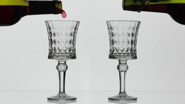 로즈 와인. 레드 와인 흰색 배경 위에 두 개의 와인 잔에 붓는다 — 비디오