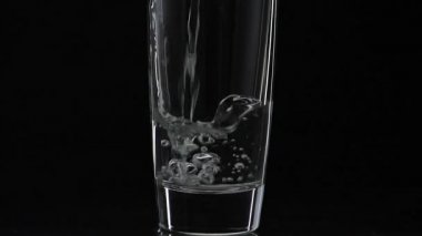 İçki bardağına bir bardak votka döküyorum. Yavaş çekim. Siyah arka plan