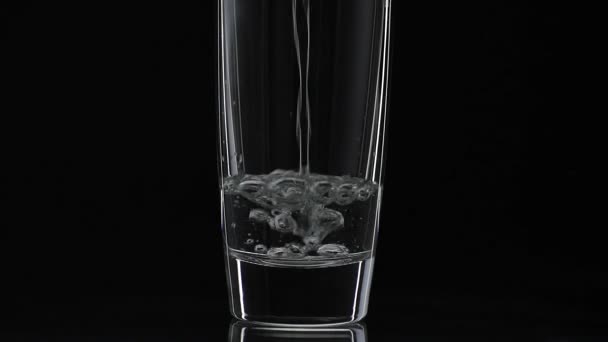 Verser de la vodka dans un verre à boire. Au ralenti. Fond noir 