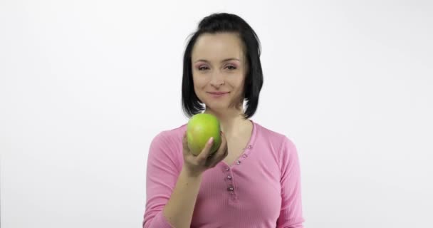 Mujer joven comiendo manzana y diciendo yum. Chica toma primer mordisco y decir quiero morder — Vídeo de stock