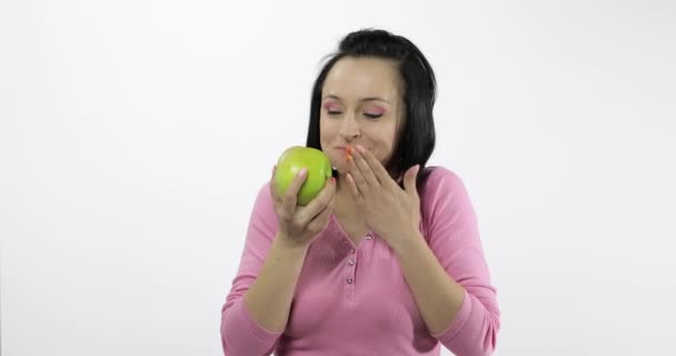 Joven hermosa mujer comiendo grande, y jugosa manzana verde sobre fondo blanco — Vídeos de Stock