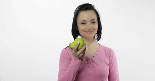 Una mujer comiendo pera fresca y dice "yum". Chica toma primer mordisco y decir quiero morder — Vídeos de Stock