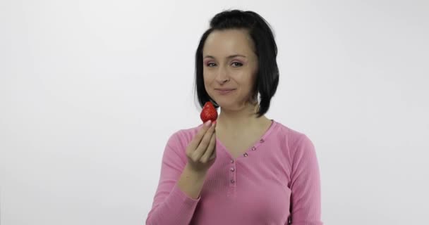 Una mujer comiendo fresa y diciendo ñam. Chica toma primer mordisco y decir quiero morder — Vídeos de Stock