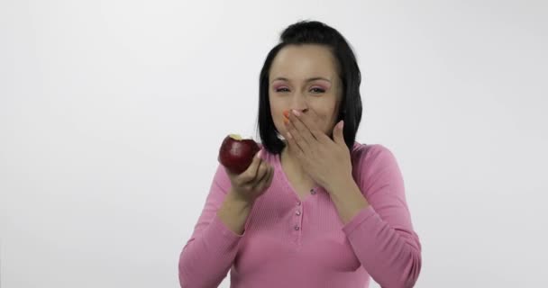 Giovane bella donna mangiare grande, fresco e succoso mela rossa su sfondo bianco — Video Stock