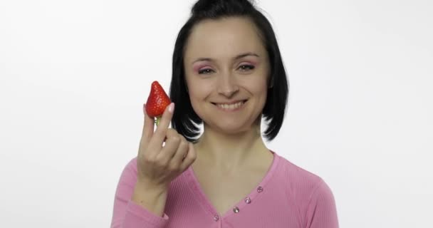 Femme mangeant des fraises et dit miam. Fille prend la première bouchée et dire vouloir mordre — Video