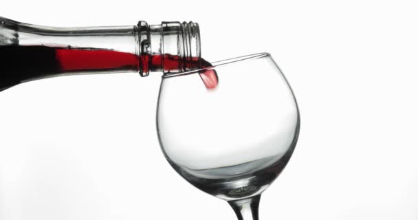 Розовое вино. Красное вино наливают в бокал вина на белом фоне — стоковое видео