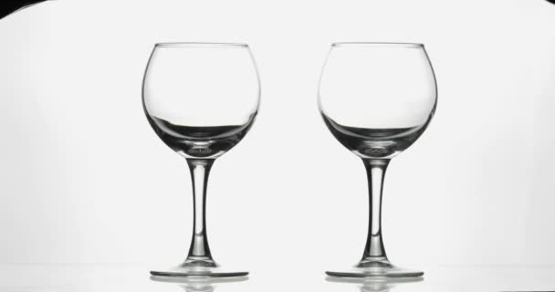 玫瑰酒红酒倒在两个酒杯的白色背景 — 图库视频影像