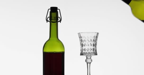 Rose wine. Red wine pour in wine glass over white background — Stock Video