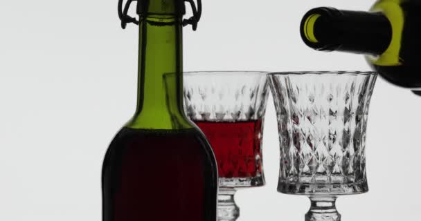 Rose wine. Red wine pour in wine glass over white background — Stock Video